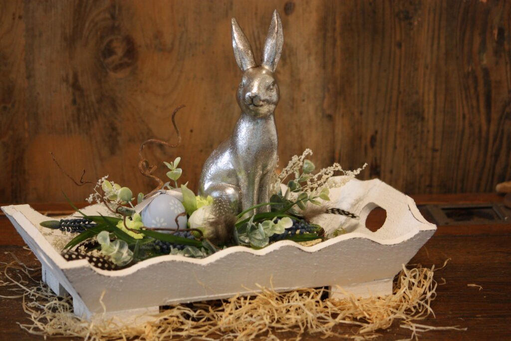 Décoration de Pâques – Le lapin argenté dans un jardin fleuri