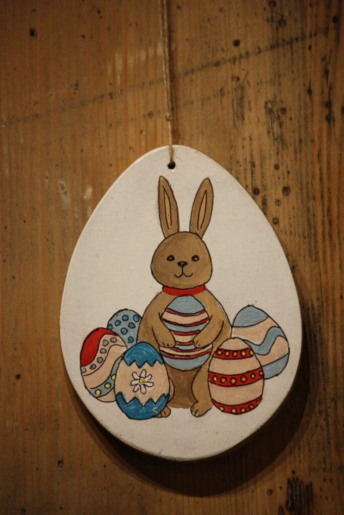 Suspension de Pâques – Le petit lapin assis au milieu d’oeufs