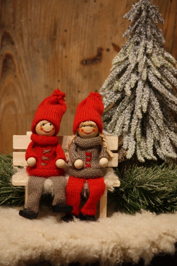 Décor d’hiver – Deux Amoureux au pull gris et rouge sur un banc en bois